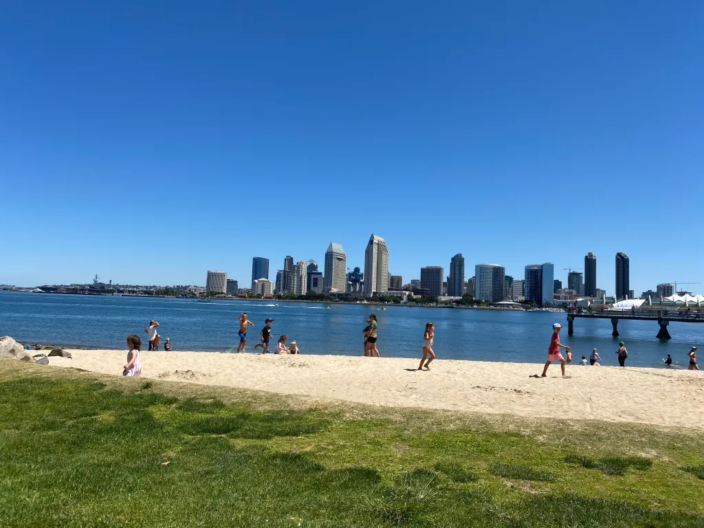 The San Diego skyline with the bay in front of it. Kids playing at the beach. A wonderful vacation idea over Memorial Day weekend.