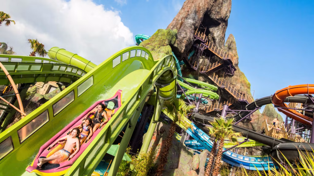 A bright green waterslide with a volcano in the background at one of the best water parks in America