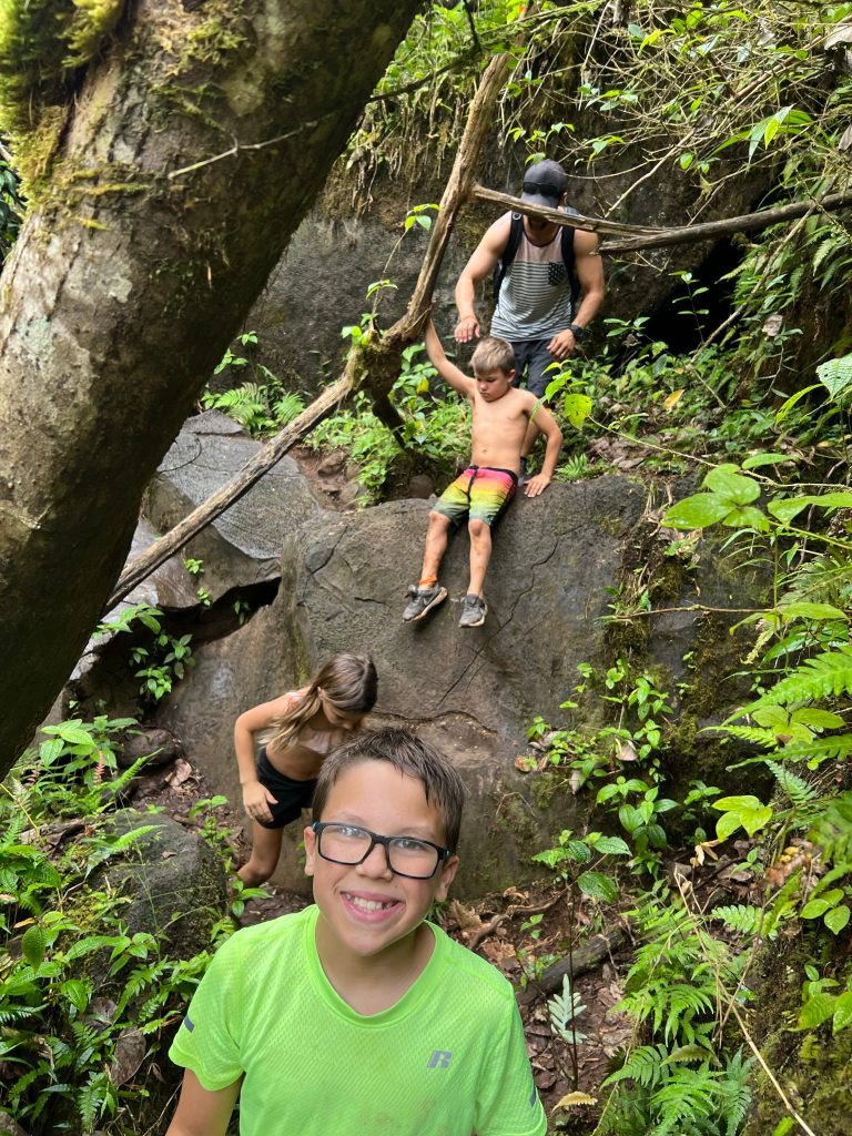 Climbing over rocks on the hike to Makaleha Falls