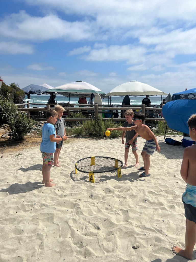 Kids playing Spike Ball, one of the best beach games for families.