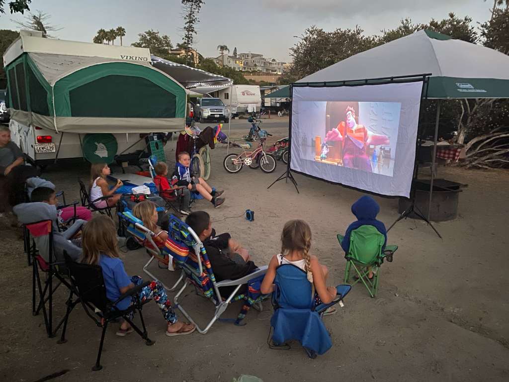 An outdoor movie night while beach camping