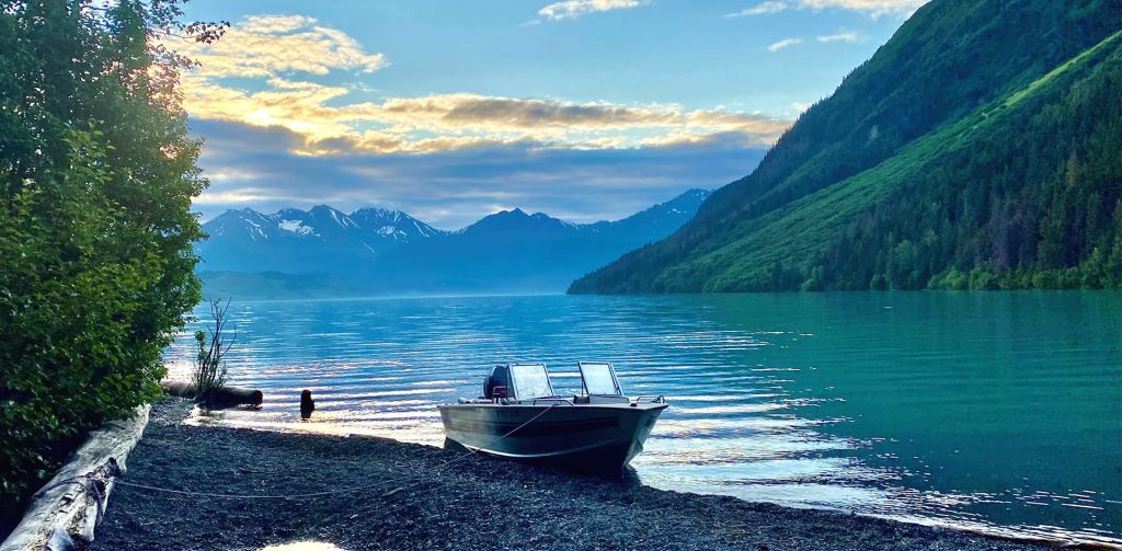 A boat with a lake and mountains behind it in Alaska, which is a top family travel destination in 2026
