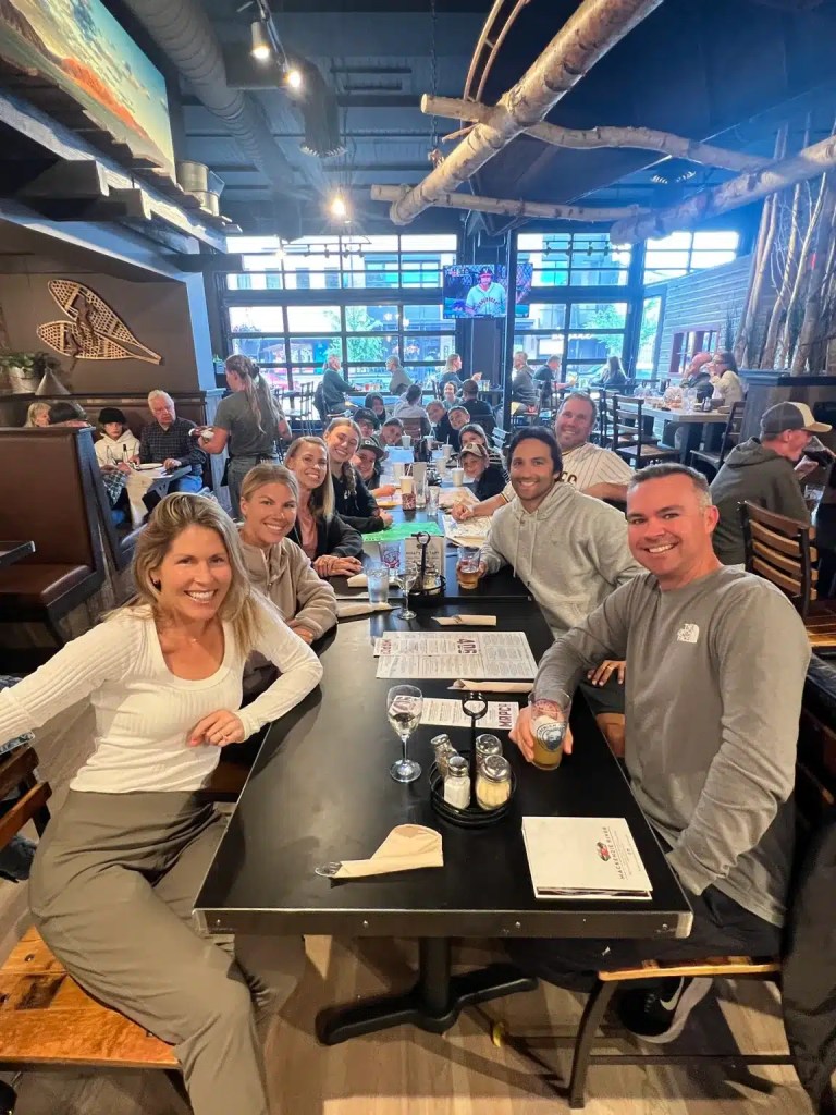 A group of adults at a large table enjoying dinner at one of the best hotels in Bozeman Montana
