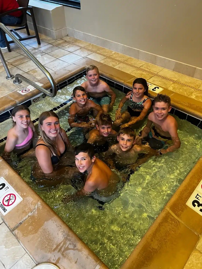A group of 9 kids smiling in the spa at one of the best hotels in Bozeman Montana