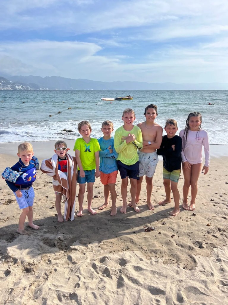 A group of kids standing at a beach in Puerto Vallarta, one of Mexico's best vacation cities