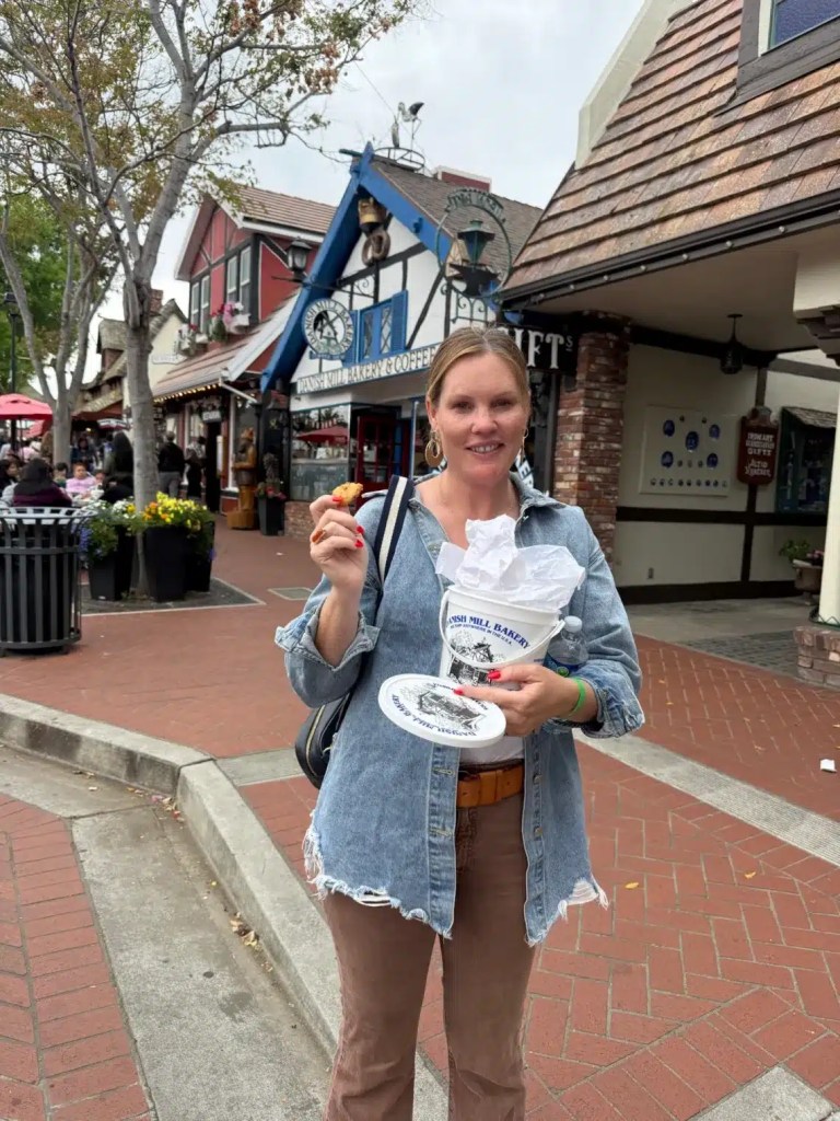 A woman holding a bin of cookies in Solvang, Ca