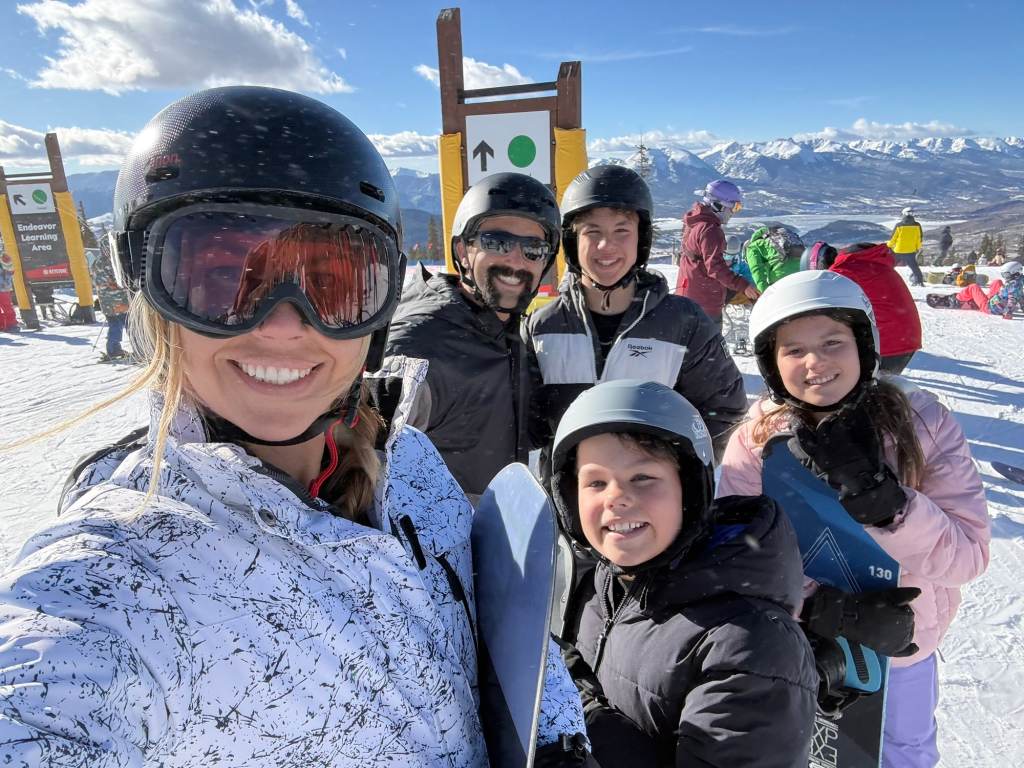A family of 5 smiling at the start of a run at one of the best places to visit in February