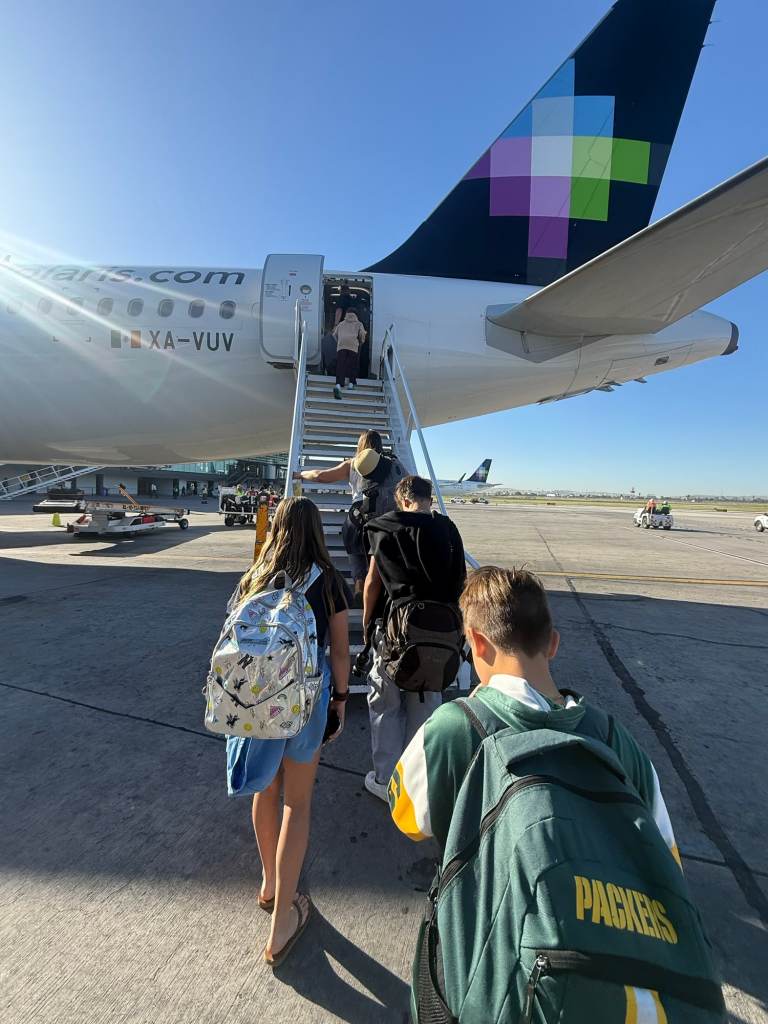 Boarding a plane with kids on the tarmac.