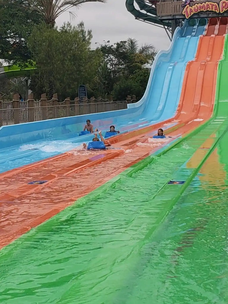 A colorful waterslide with kids racing down at one of the best water parks in America