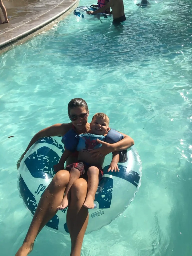 A mom and child floating in a lazy river at a waterpark in Palm Desert