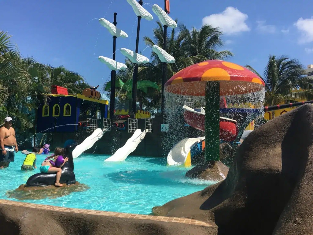 A kids play structure with waterslides at a resort in Cancun