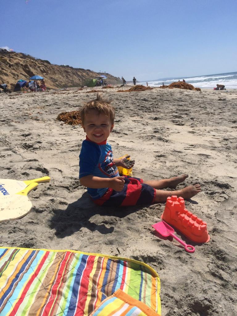 A toddler playing in the sand at the South Carlsbad state beach campground