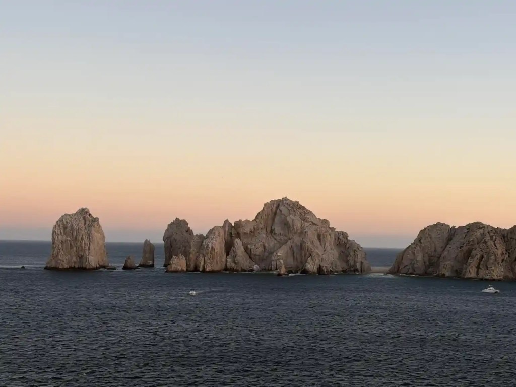 A sunset over the iconic rock formation at Land's End in Cabo