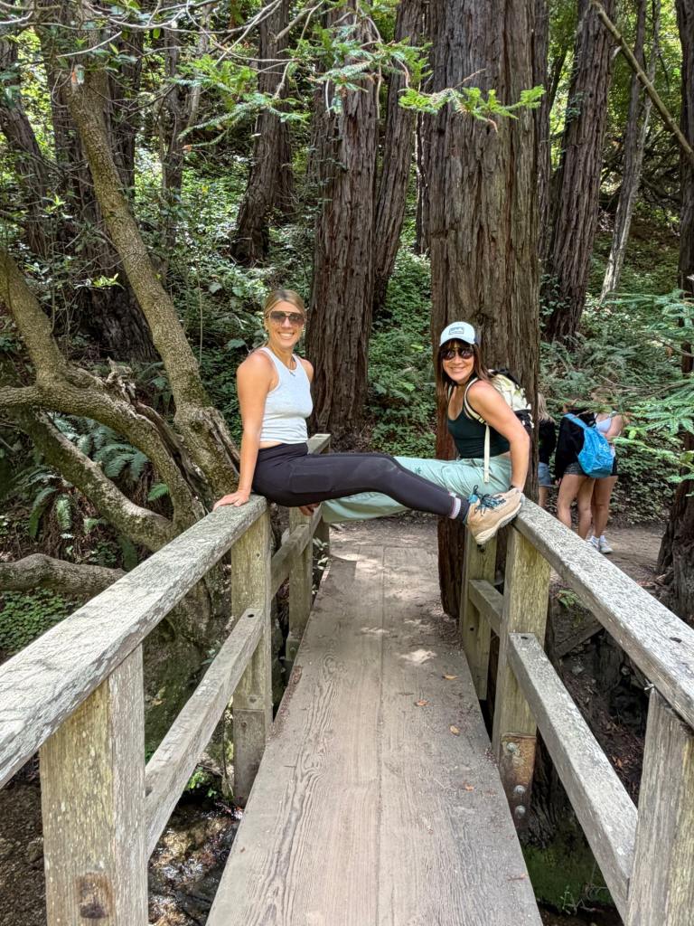 Posing on a bridge with redwoods in the background at a hike near the Pfeiffer Big Sur campground
