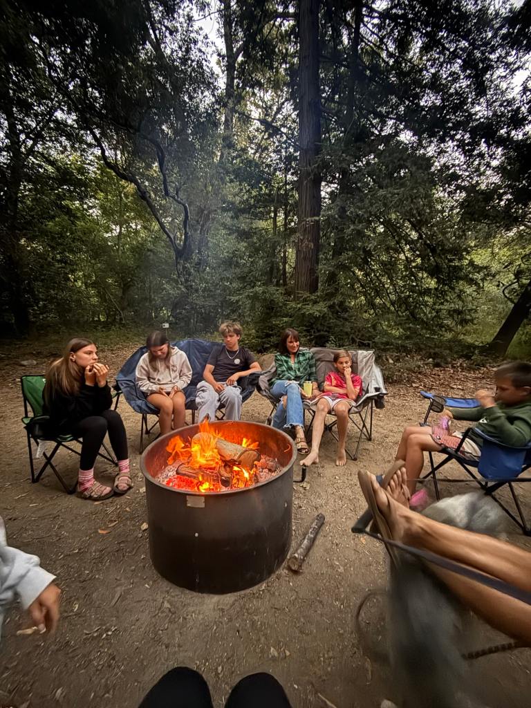 A family sitting around the campfire at Pfeiffer Big Sur campground.