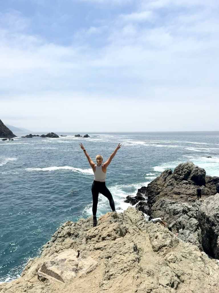 A woman posing on a rock formation near the Pfeiffer Big Sur campground