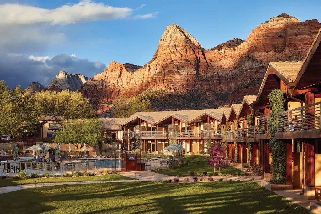 A Zion park hotel with red rock landscape behind it