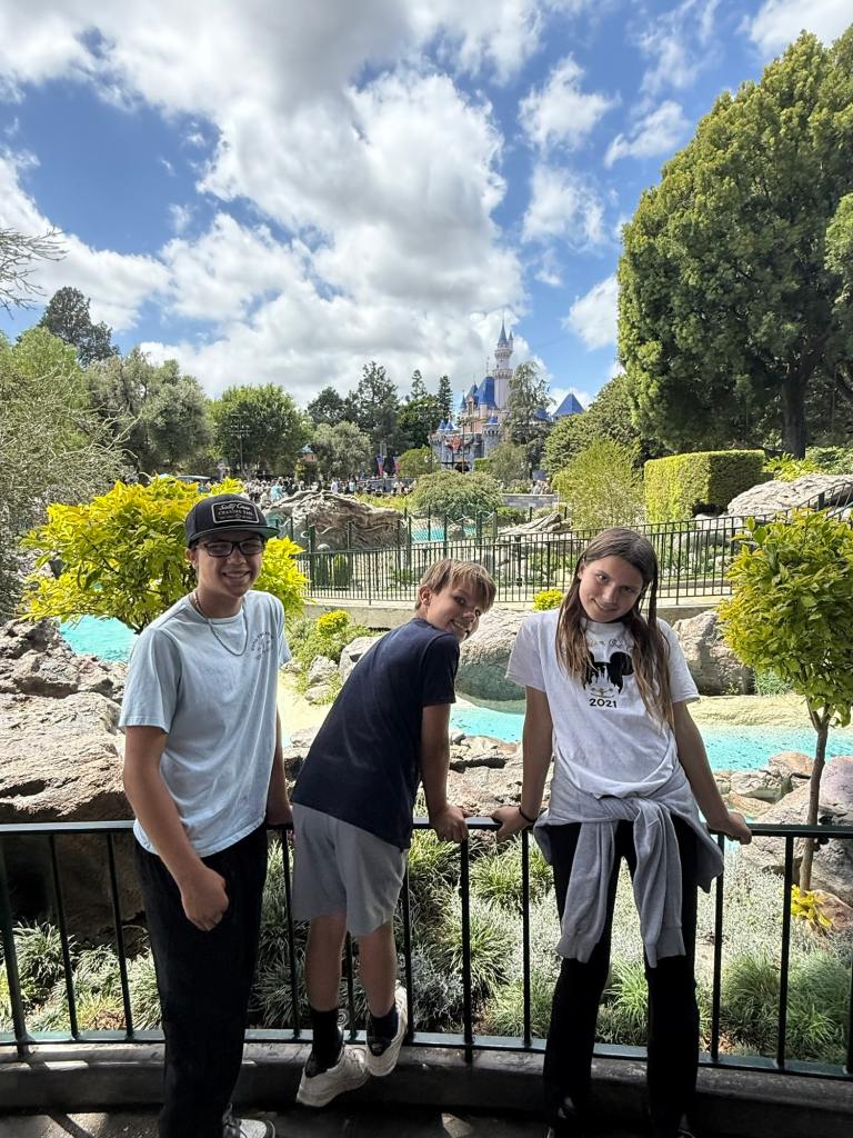 Three kids posing at one of the greatest amusement parks in the world