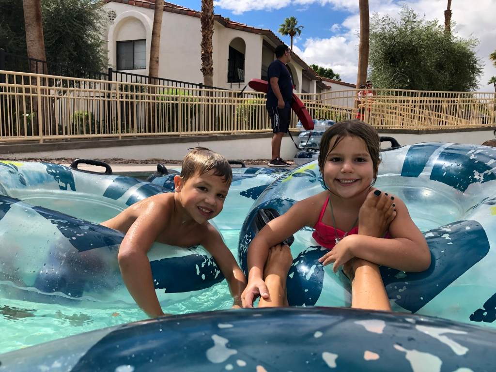Two smiling kids and a lifeguard on a picture of the lazy river at the Omni Rancho Las Palms in Palm Springs