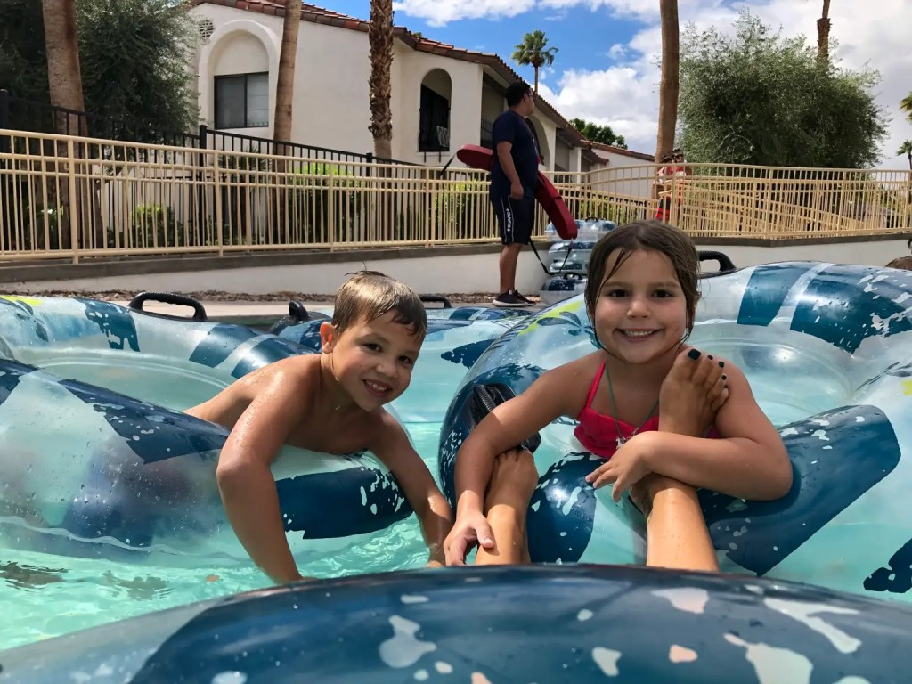 Two smiling kids and a lifeguard on a picture of the lazy river at the Omni Rancho Las Palms in Palm Springs
