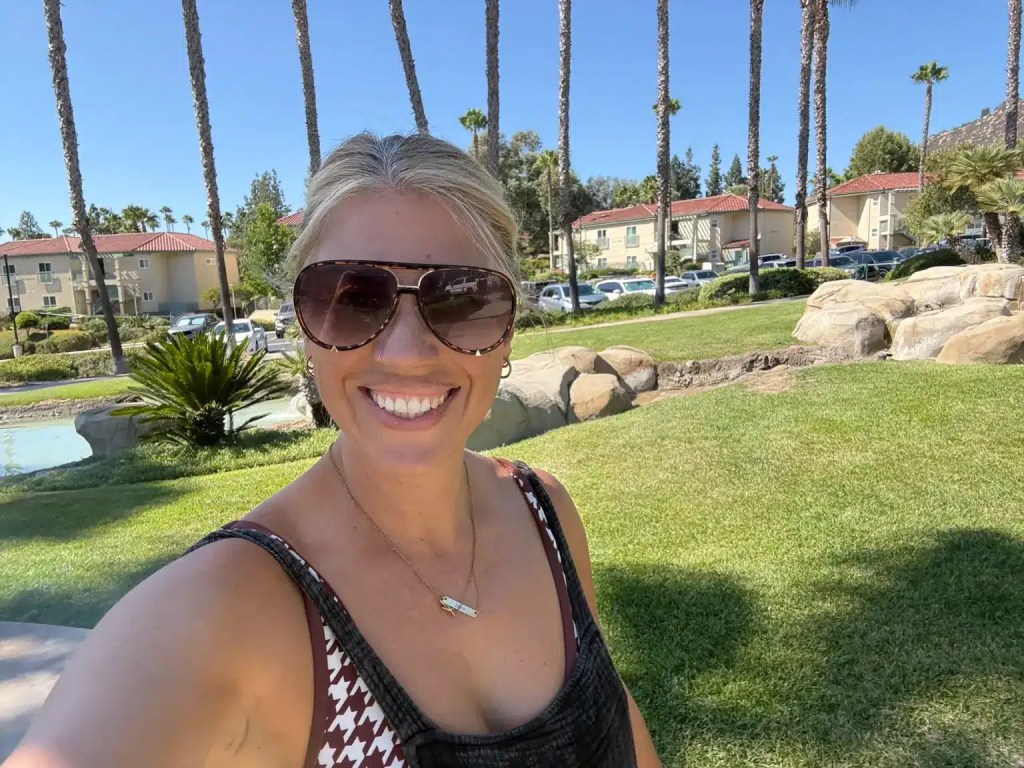 A woman smiling with the Welk Resort in Escondido behind her