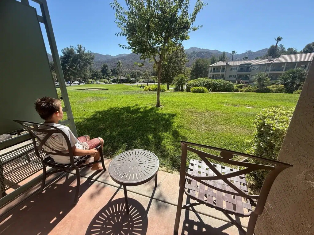 A boy sitting on the patio of his room at the Welk Resort in Escondido