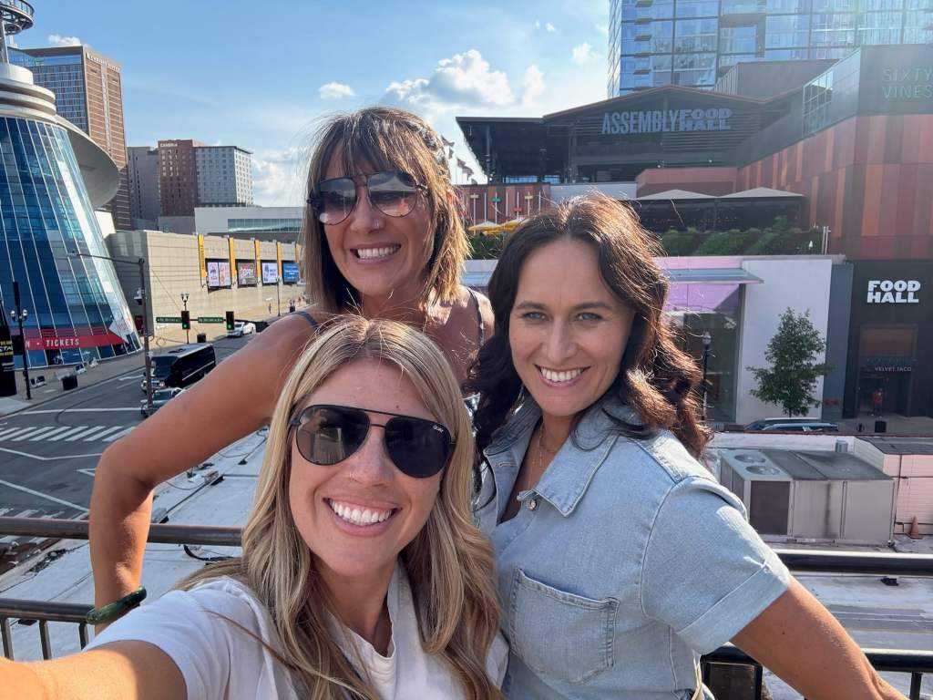 A group of three women posing from the balcony at one of the boutique hotels in Nashville