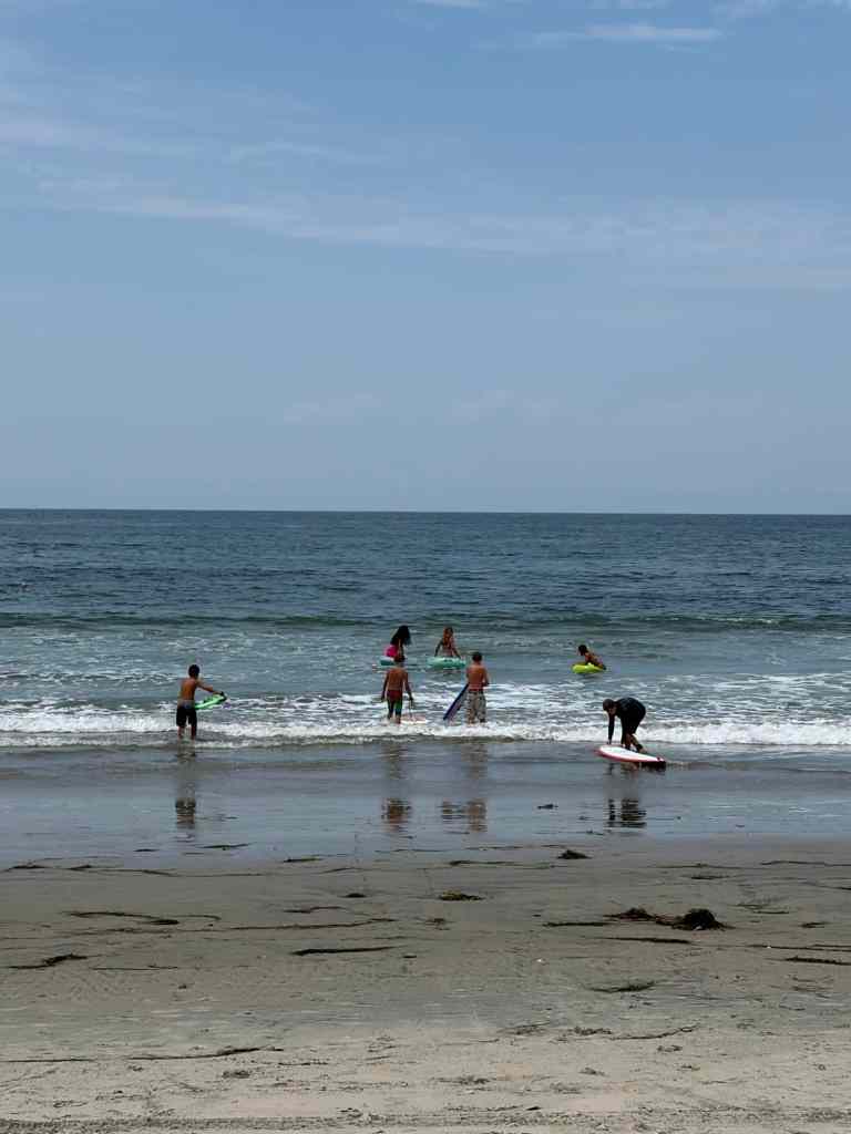 Kids with surf boards and boogie boards at one of the best southern California beaches