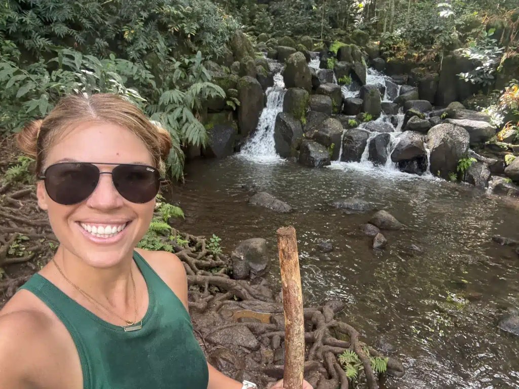 A woman posing with some small waterfalls in Kauai, Hawaii