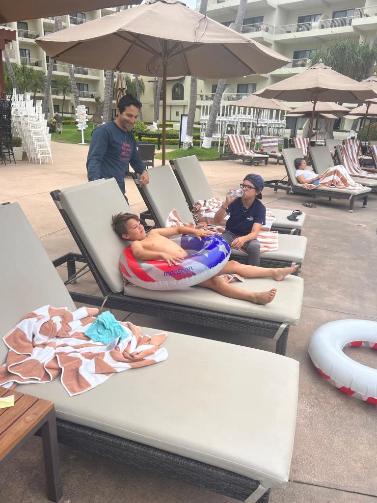 A kid with an innertube lounging by the pool while staying at one of the best family beach resorts
